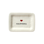 small dish with black text  that reads "California" with a small red heart centered above the text.