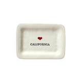 small dish with black text  that reads "California" with a small red heart centered above the text.