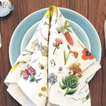 Wildflower tea towel folded neatly on top of two blue plates. 