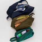 set of 3 travel bags, all unzipped and filled with various travel supplies. 