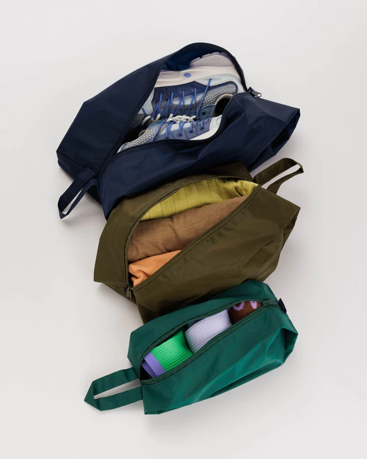 set of 3 travel bags, all unzipped and filled with various travel supplies. 