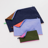Set of 3 pouches in varying size and colors, laid flat to show size range. 
