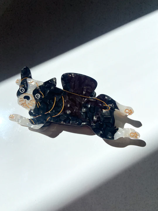 BLACK AND WHITE BULL DOG LAYING ON WITH A CLASSICALLY STUNNED GAVE. GOLD ACCENTS PAINTED ON SHOWING FACE, FEET, AND BODY DETAILS. 