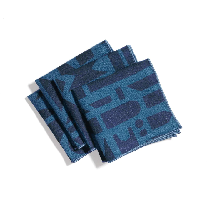 Set of four blue napkins, neatly folded on next to eachother. The napkins have a light blue background and a slightly darker blue print. 