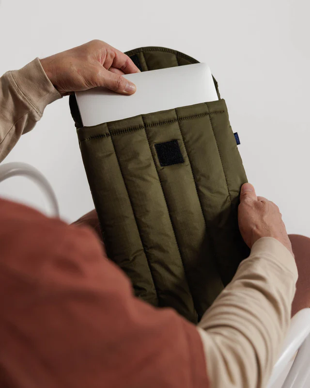 Person pulling a laptop out of tamarind colored laptop case. 