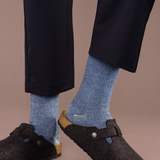 image shows a person from the knees down. the person is wearing dark blue plants and dark shoes with the blue socks providing a nice contrast between the other items.