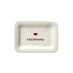 small dish with black text  that reads "California" with a small red heart centered above the text. 