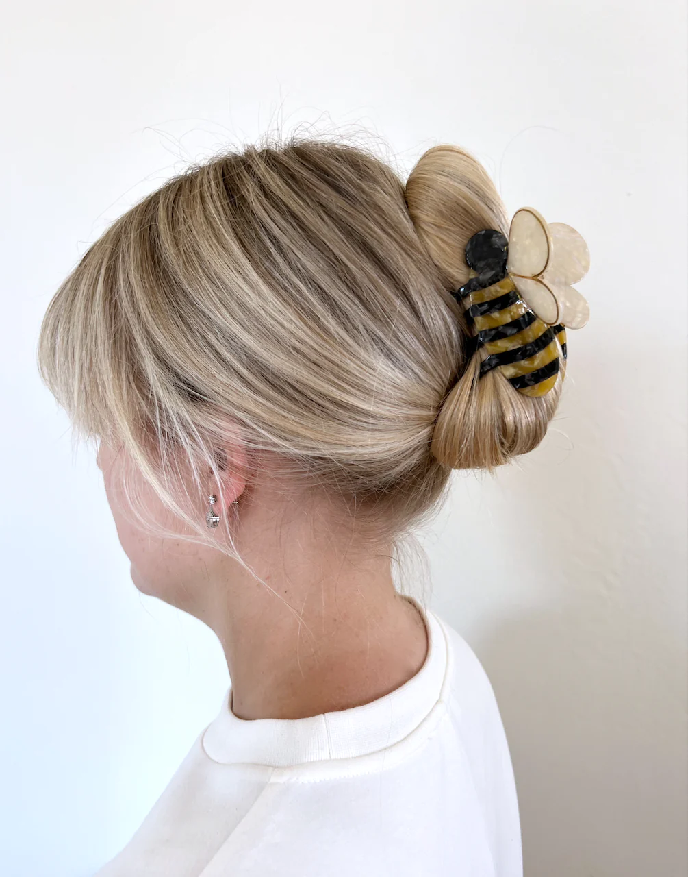 THE BUMBLE BEE CLIP IN USE HOLDING SOMEONE HAIR UP. 