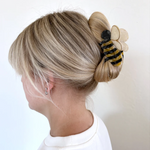 THE BUMBLE BEE CLIP IN USE HOLDING SOMEONE HAIR UP. 