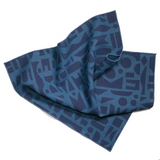 Napkin with a blue geometric print in a position that allows you to see a lot of the print and the size of the napkin, 