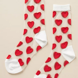 Sheer socks with red hearts and white detailing at the top and toe of the sock. 