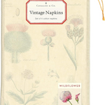 Wildflower napkins folded in muslin bag with a white sticker that reads" Vintage Napkins". The bag has a small sticker on the bottom right corner with a pink wildflower signifying the style of napkin thats in the bag.