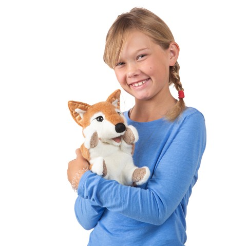 young child holds the shiba inu puppy puppet in her arms and she and the puppet both smile for the camera. 
