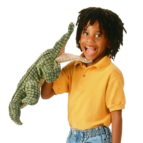 young child holding the alligator hand puppet. Alligator has and oepn mouth and the child has big open mouth smile. 