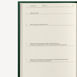 Photo shows  the jounral open to a page that has 4 different journal prompts with space to answer said prompts. 