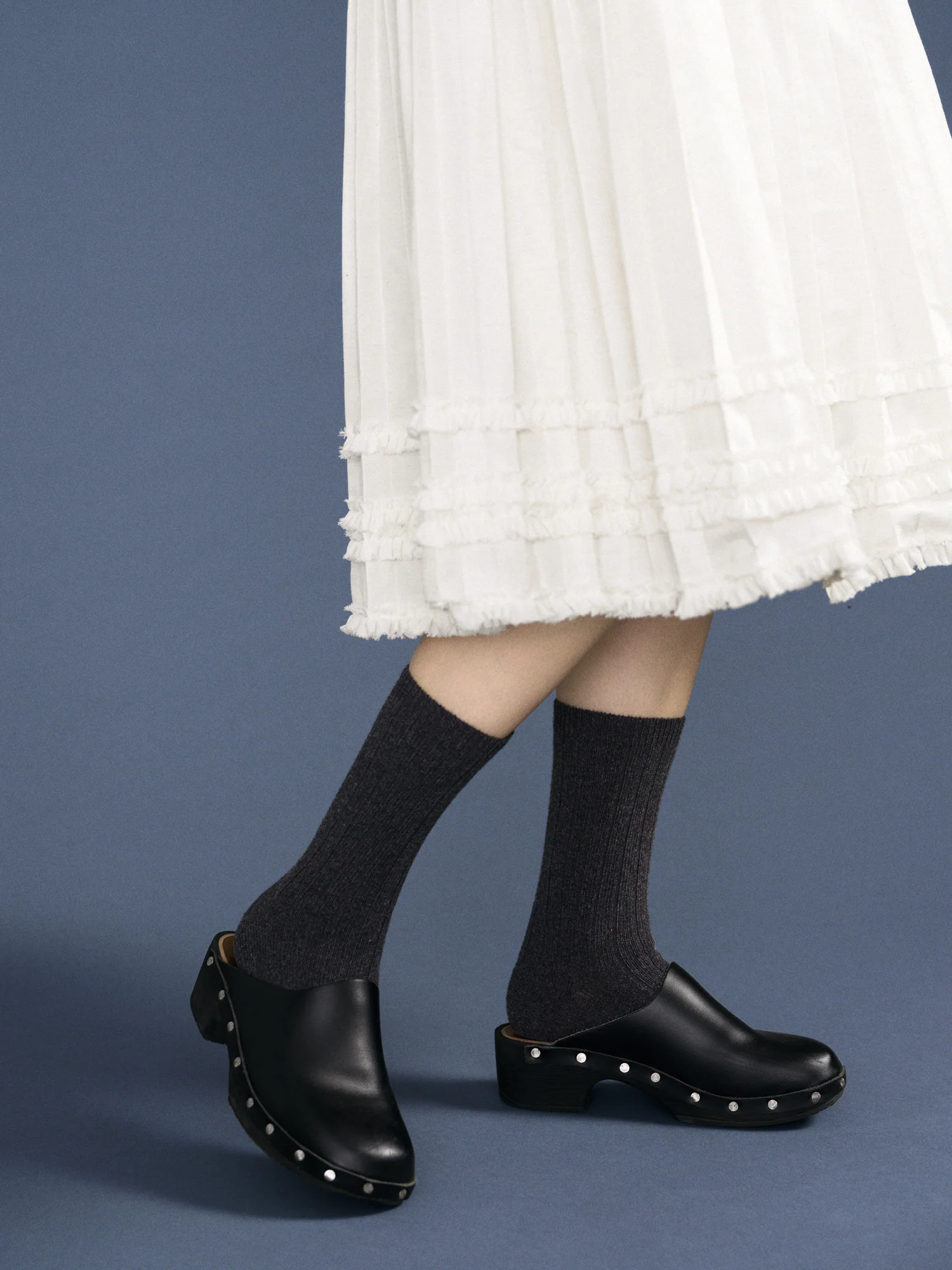 gray cashmere socks paired with a frilly white skirt and black clogs. 