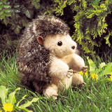 small brown hedgehog puppet in a nature landscape. 