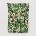 laptop case with flower and grass print in front of white background. 