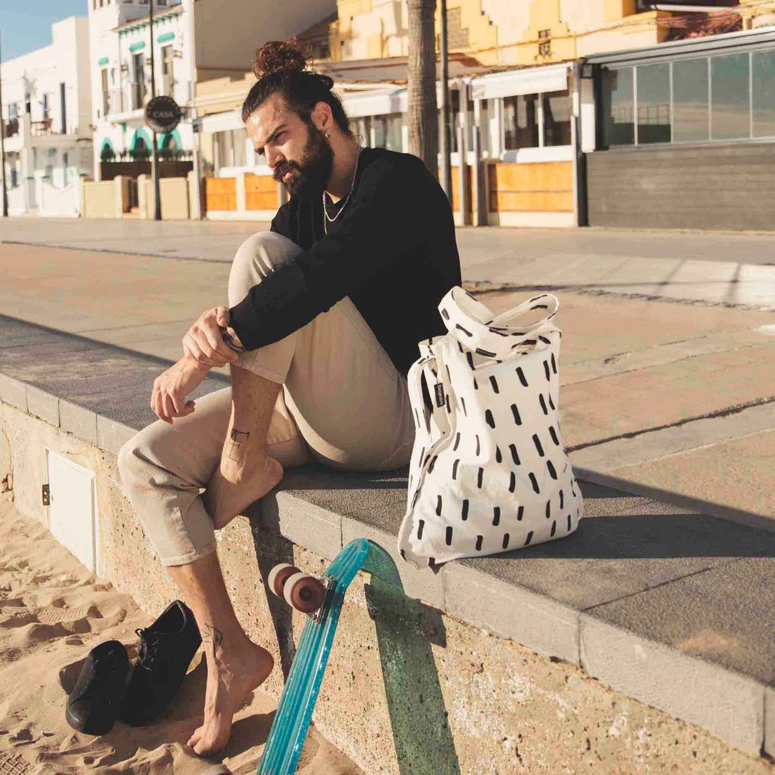 Man at Beach with Black Brush Bag / Backpack