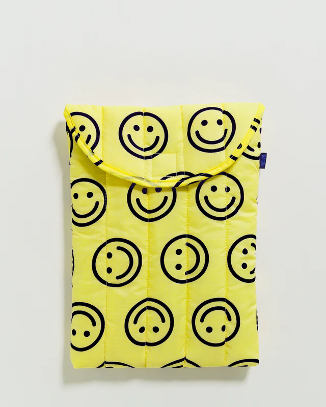 bright yellow laptop case with simple smiley faces. In front of white background. 